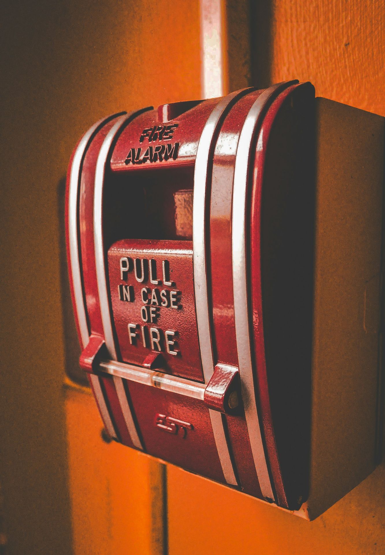 Manual fire alarm pull station mounted on a wall, used for triggering emergency alerts in a conventional FDAS setup.